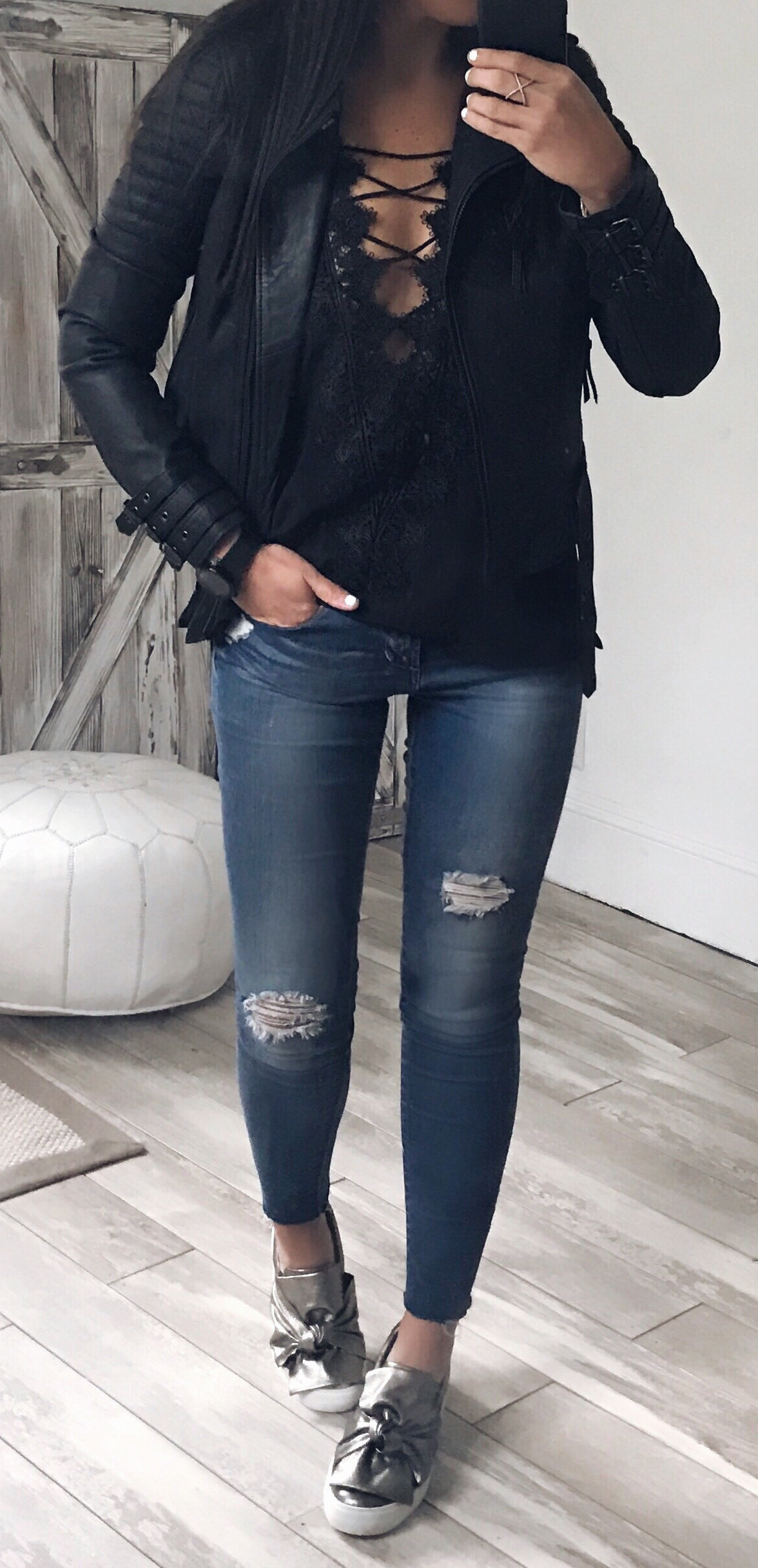 women's black full zipped leather jacket and; blue distressed jeans