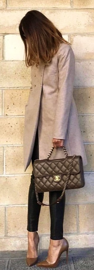 Grey double-breasted overcoat with quilted black Chanel 2-way handbag.