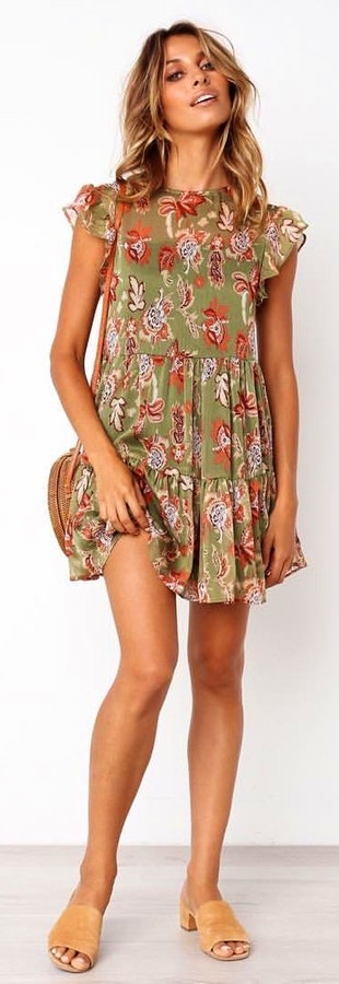 Woman in green and orange floral cap-sleeved mini dress with crossbody bag outfit.