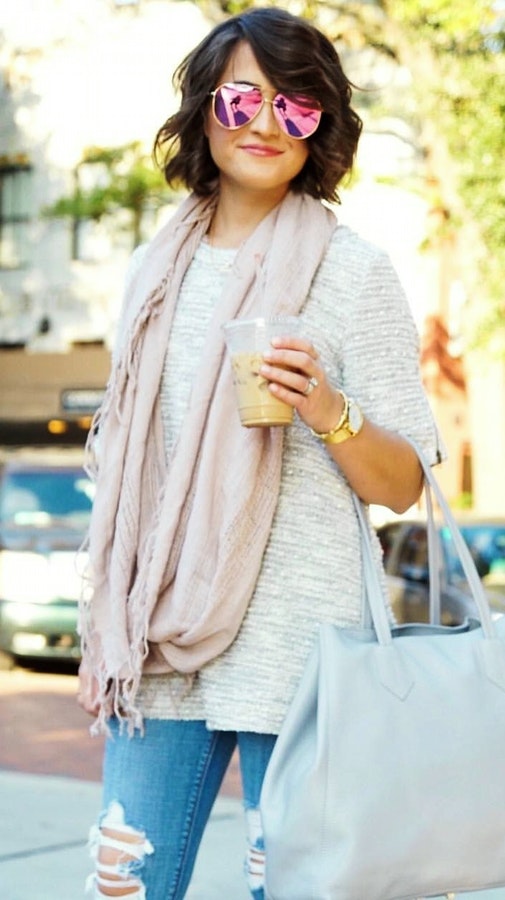 Woman wearing pink scarf and grey crew-neck shirt.