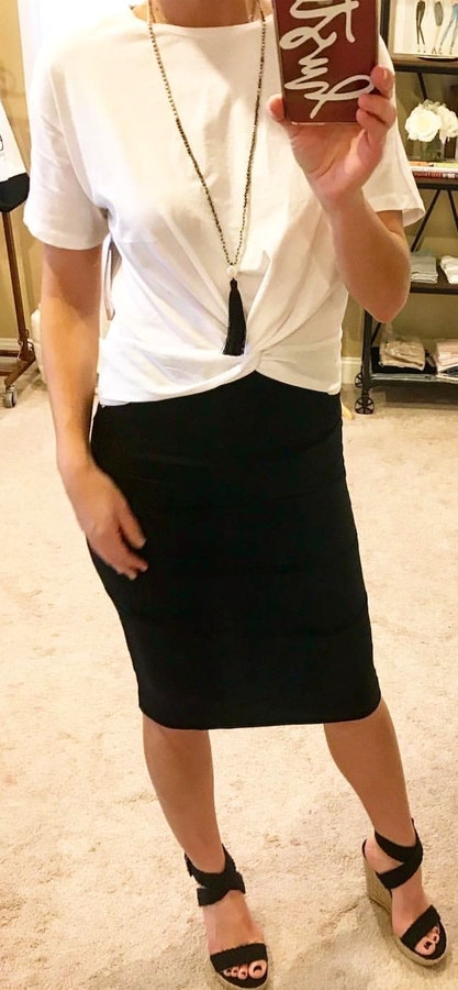 Woman wearing white shirt and black skirt.