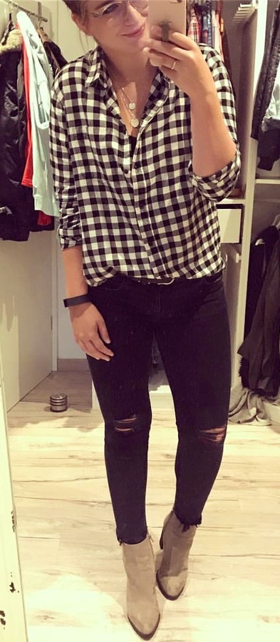 White and black checked sports shirt and black distressed denim jeans.