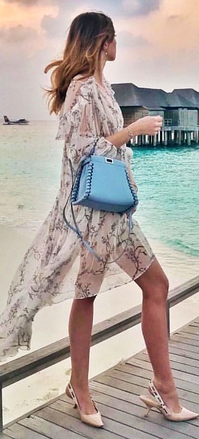 Beige and black floral long-sleeved dress and blue tote bag.