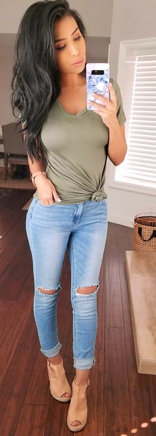 Green scoop neck t-shirt, distressed blue jeans with ankle boots.