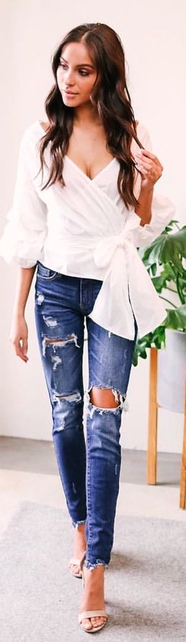 Interesting white v-neck 3 – 4 sleeved blouse and blue distressed jeans with high heels.