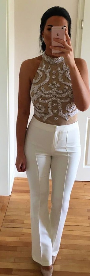 Sequined sleeveless crop-top and white pants.