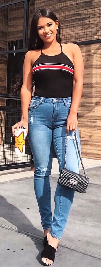 Spaghetti strap tank top and blue jeans with black purse.