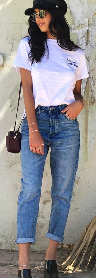 White and black crew-neck t-shirt, shoulder handbag and blue denim jeans