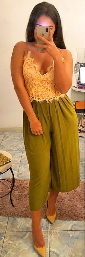 White lace spaghetti-strap crop top and green wide-leg capri pants.