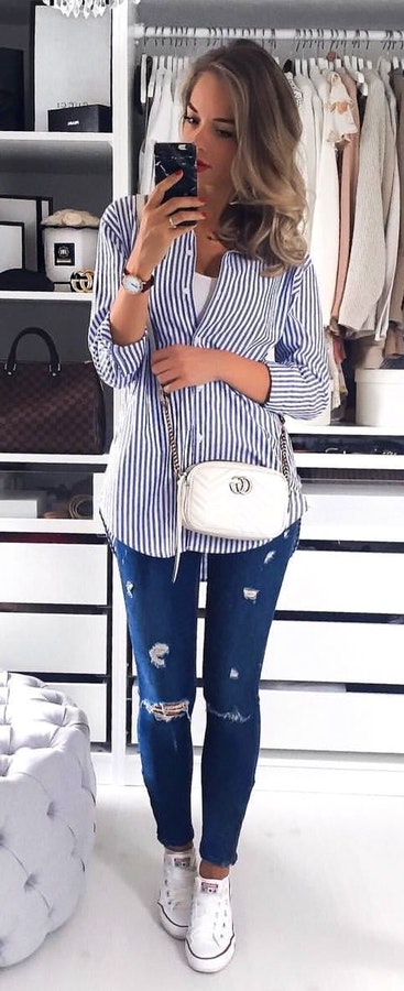 women's white and blue pinstriped button-up dress shirt, distressed blue denim fitted jeans, and pair of white Converse low-top sneakers outfit.