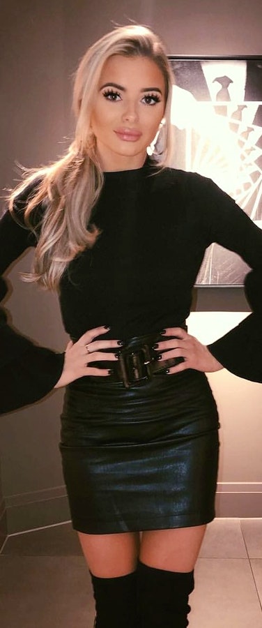 Black long-sleeved top with black leather mini skirt.