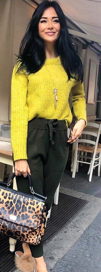 Smiling woman wearing yellow sweater.