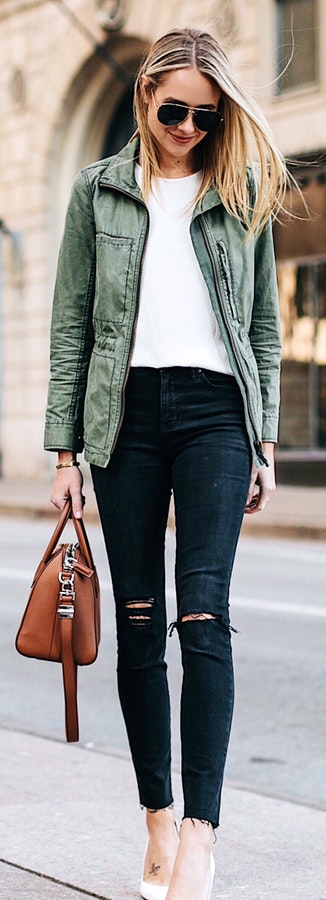 Woman in grey zip-up jacket carrying brown leather bag.