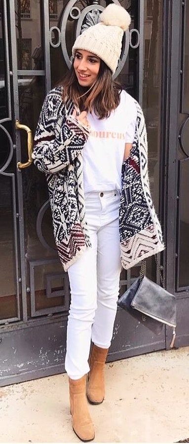 Woman wearing black and white tribal print jacket and beige bobble cap.