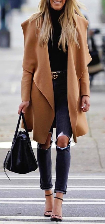 Women's brown formal suit jacket and black distressed jeans.