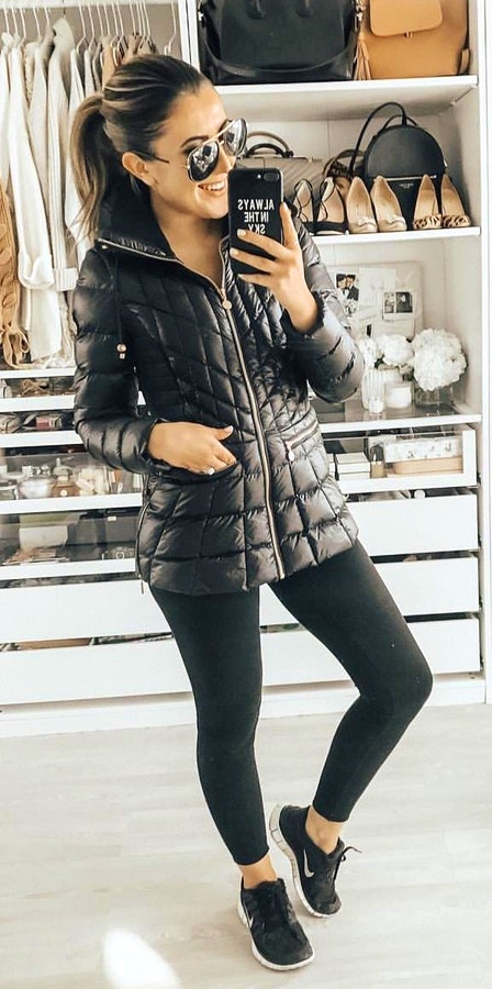 women's black leather zip-up bubble jacket with black leggings.