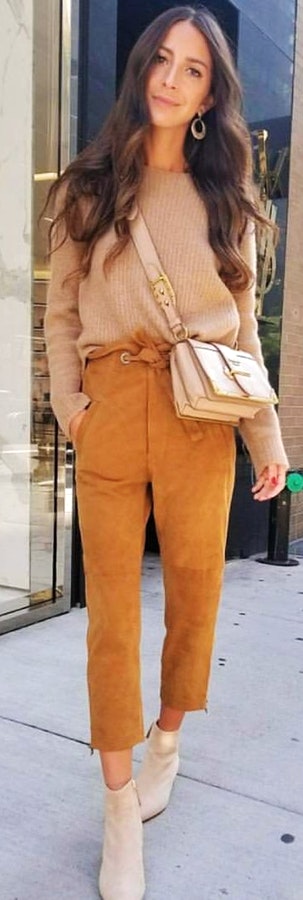 Woman in brown sweater, brown pants, brown leather crossbody bag, and brown suede booties outfit.