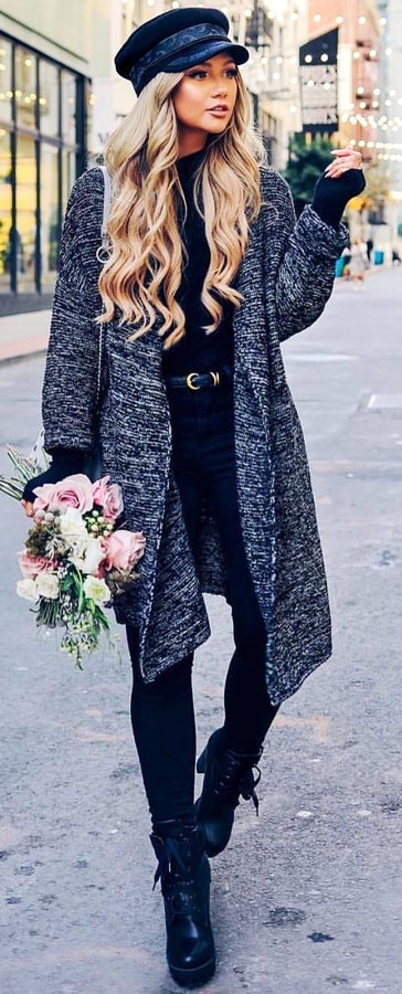 Woman in gray cardigan holding pink and white roses.