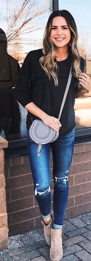 Woman wearing black 3-4-sleeved shirt, distressed jeans, and gray suede booties outfit.