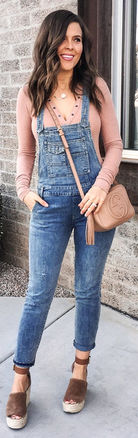 Woman wearing blue denim overall pants and beige long-sleeved shirt..