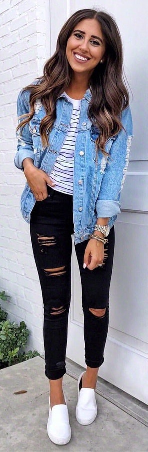 Woman wearing distressed blue button-up jacket and black fitted jeans.