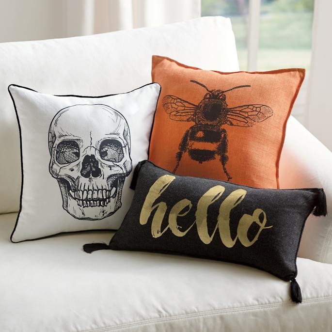 Halloween toss pillows, featuring a skull, a bee, and hello.