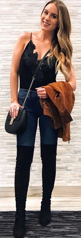 Woman wearing black spaghetti strap top and black jeans.