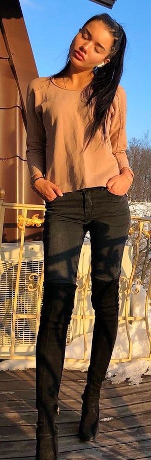 Woman wearing brown scoop-neck long-sleeved shirt and black pants.