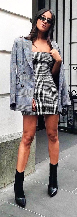 Woman wearing gray and white tube-neckline mini dress with gray suit jacket.