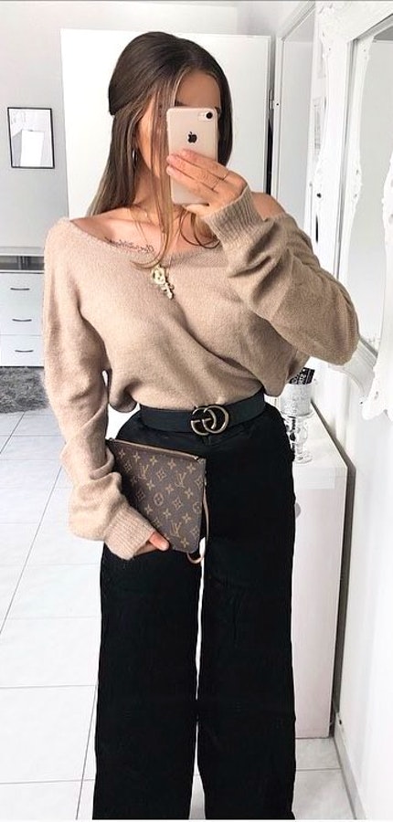 woman wearing grey sweater and black slacks.