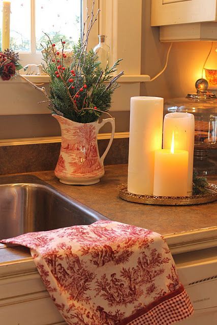 Change flowers in kitchen to evergreens. Love the toile dish towel.