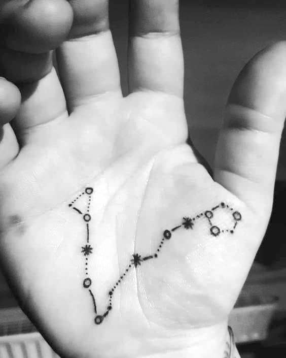 An unexpected palm tattoo of the Pisces constellation.