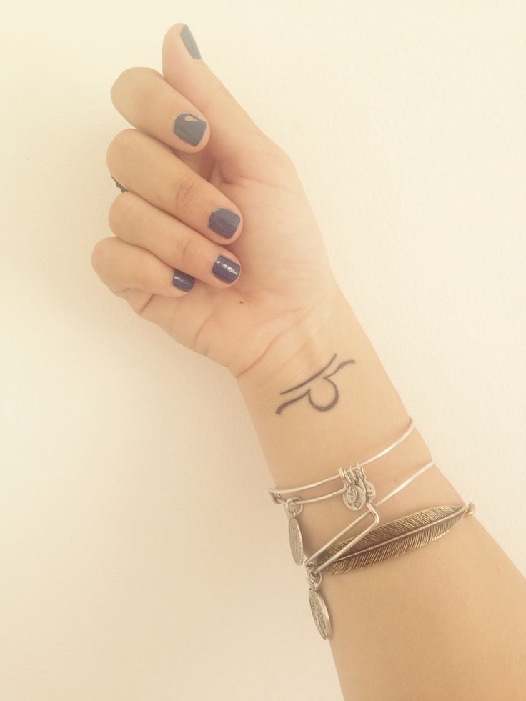 Centered Libra symbol on a wrist.