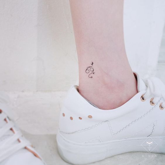 Tiny Cancer symbol ankle tattoo.