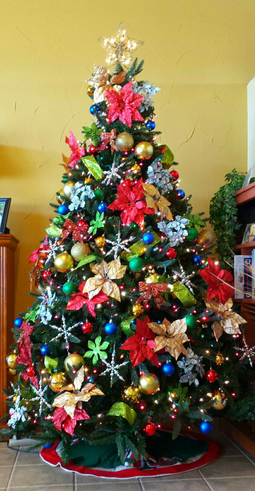 Christmas tree with red, gold, silver, blue, green, snowflakes, poinsettias, ribbon and lots of sparkle!